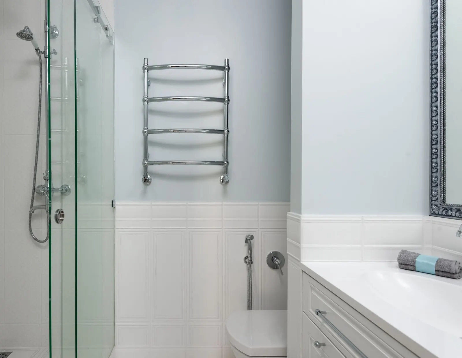 Interior of modern bathroom with sink on cabinet and toilet at wall near glass door of shower cabin at home